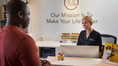 male customer at front desk of wellness business 